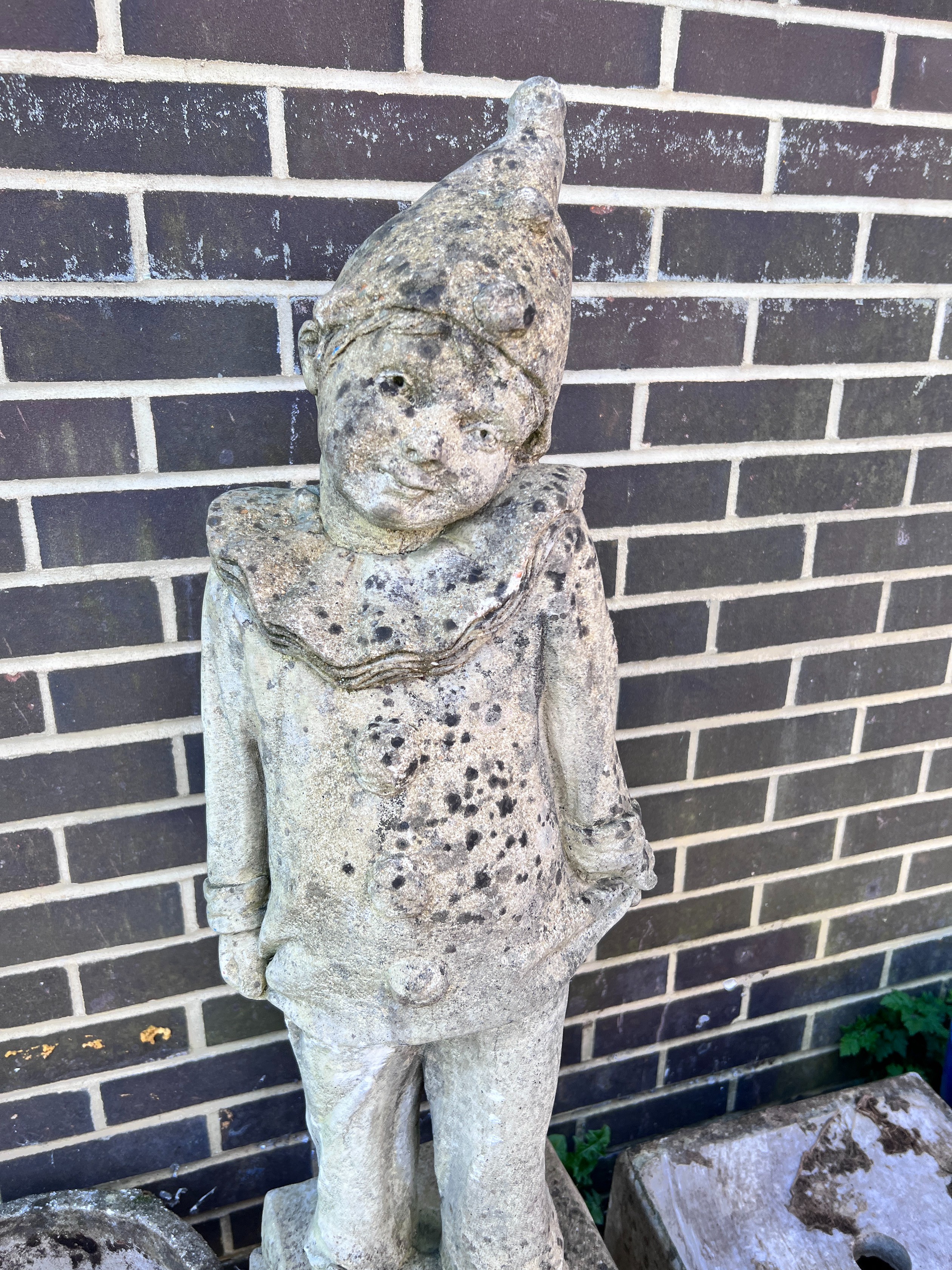 A reconstituted stone garden pierrot on square plinth, height 130cm *Please note the sale commences at 9am.